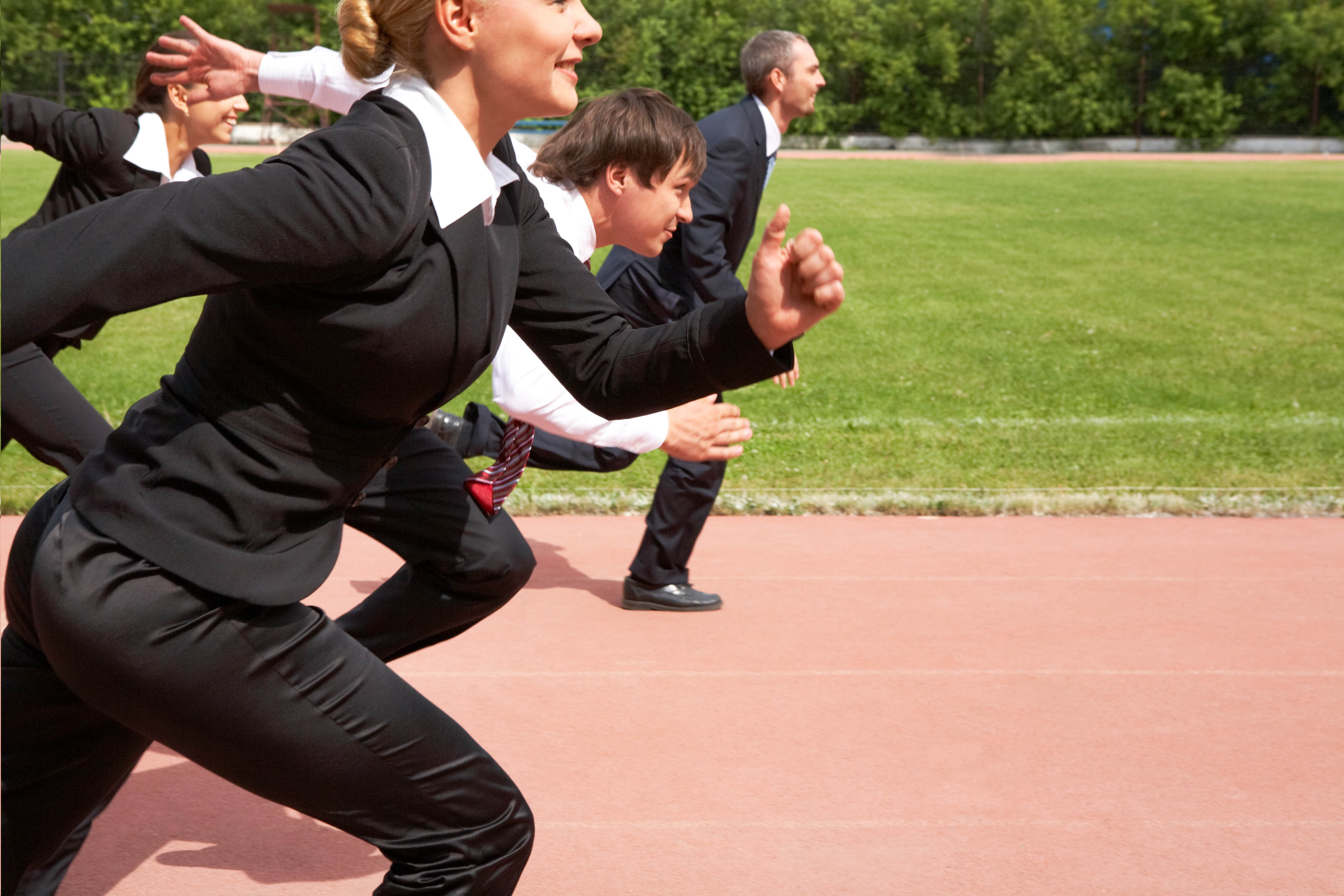 Business people in suits running around a track Business people in suits running around a track